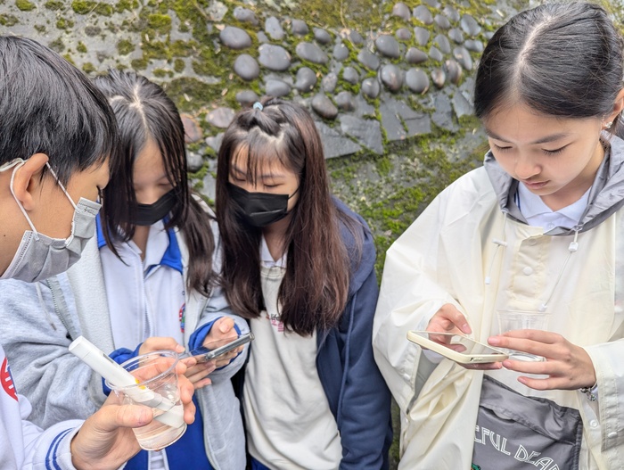 學生在烏塗溪量測水質數值後進行記錄